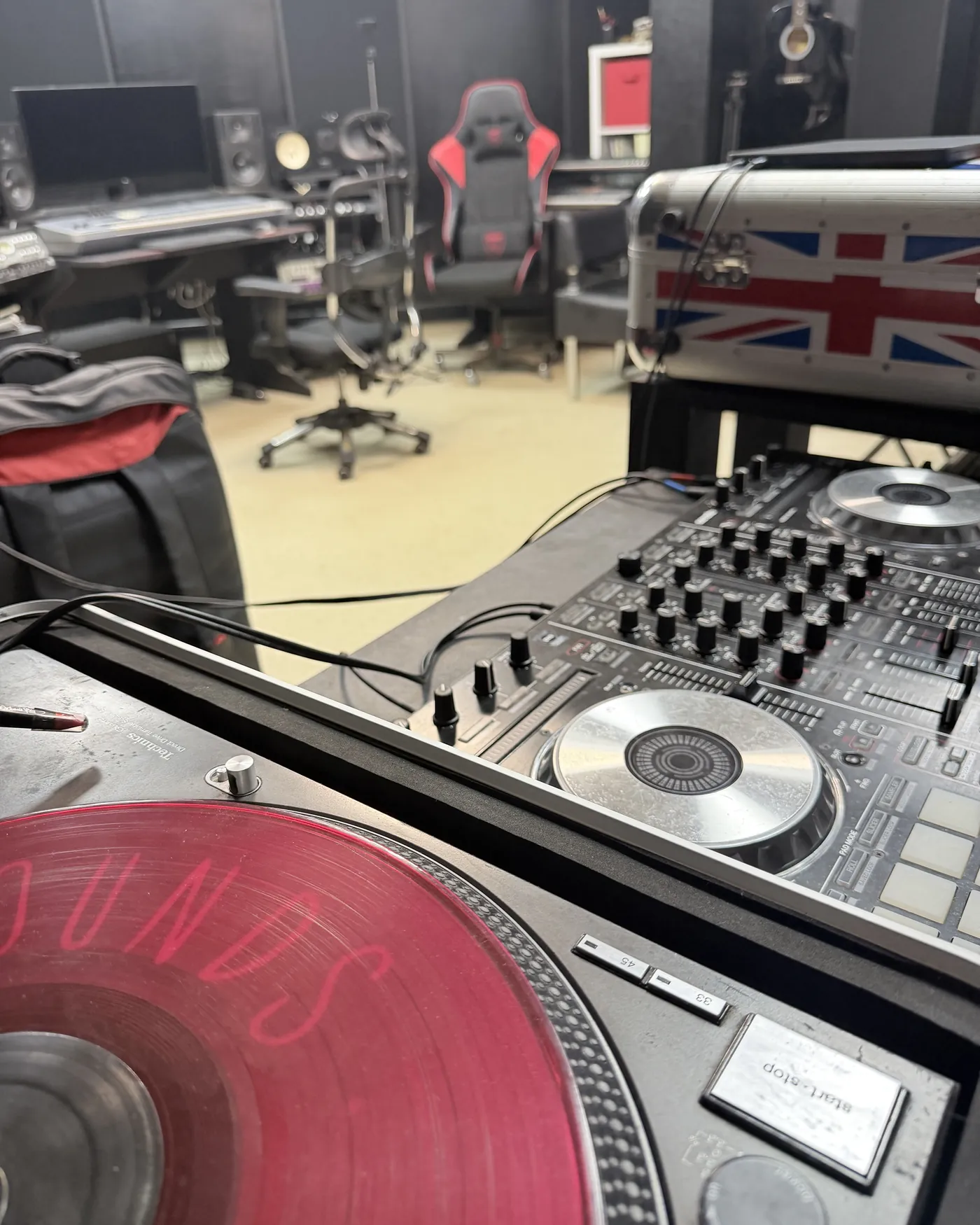 Зал ЧЁРНЫЙ: DJ-пульт и вертушка с красной пластинкой, за ними студийный стол